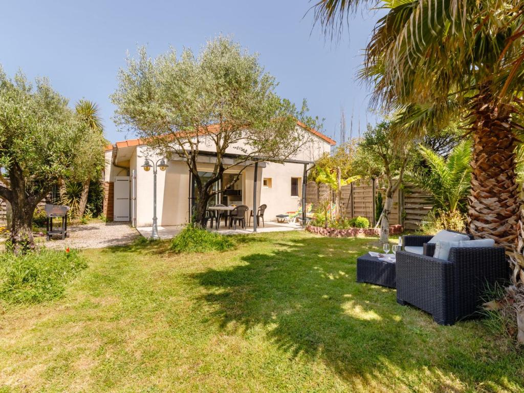 塔勒蒙的住宿－Holiday Home Les Oliviers - TSH111 by Interhome，后院,有房子和棕榈树