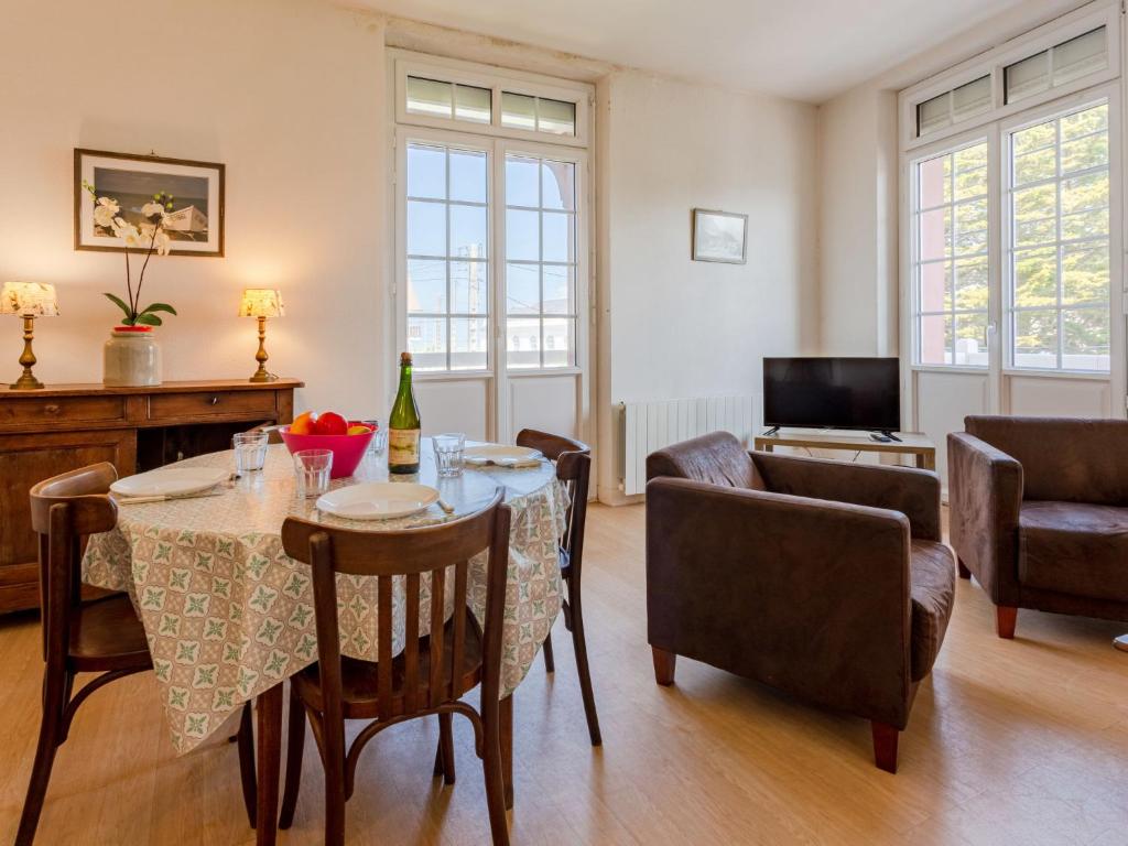 een woonkamer met een tafel en stoelen bij Apartment Le Manoir du Casino by Interhome in Cabourg