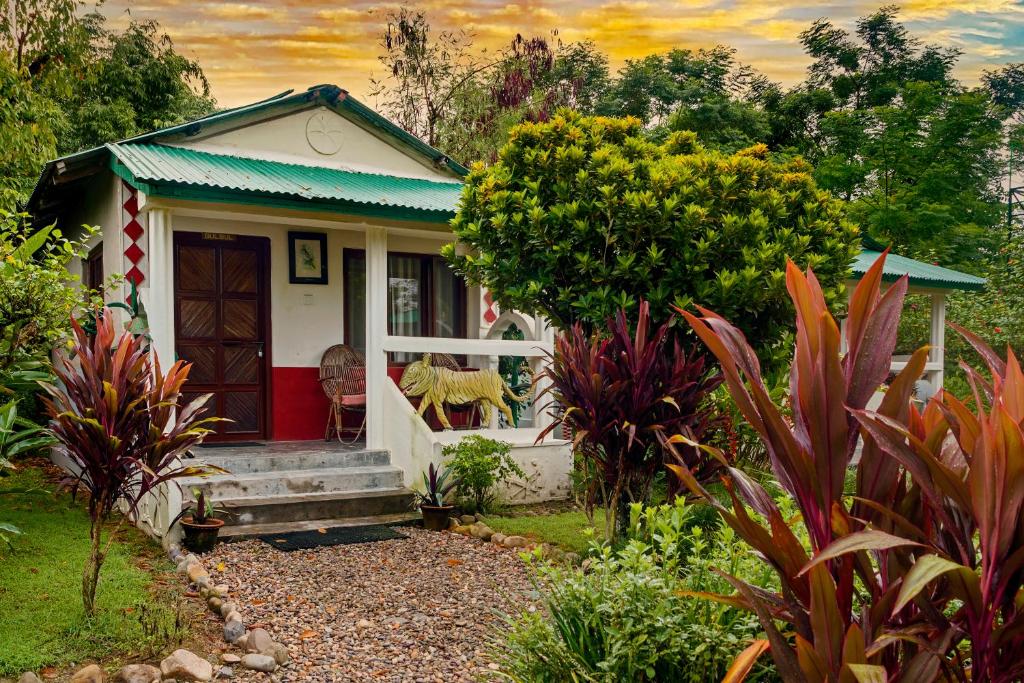 une petite maison avec une porte rouge dans un jardin dans l'établissement Machan Country Villa, à Chitwan