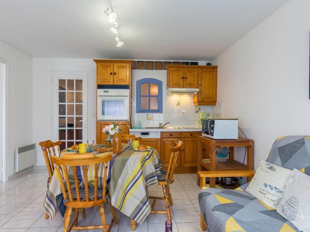 una cucina con tavolo, sedie e divano di Apartment Ty Bugale by Interhome a Concarneau