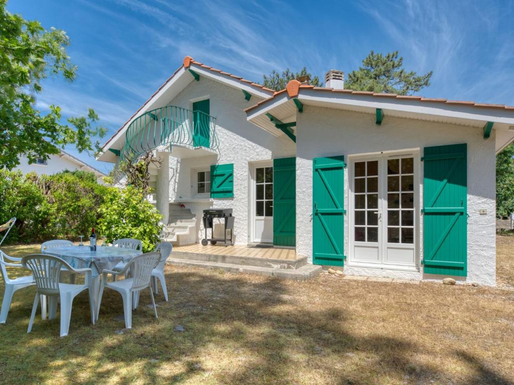 ein Tisch und Stühle vor einem Haus in der Unterkunft Holiday Home La Bruyère by Interhome in Montalivet-les-Bains