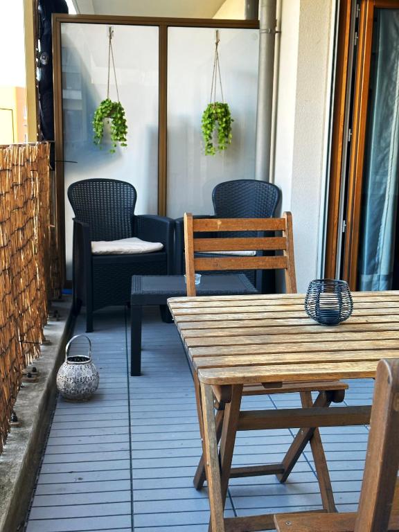 une table et des chaises sur une terrasse avec des plantes dans l'établissement Havre de paix à 15mn Paris et 15mn Stade de France, à Saint-Denis
