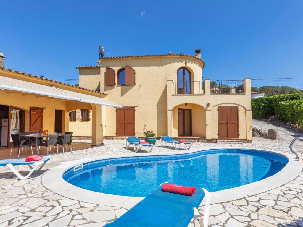 a villa with a swimming pool in front of a house at Holiday Home Solenza by Interhome in Calonge