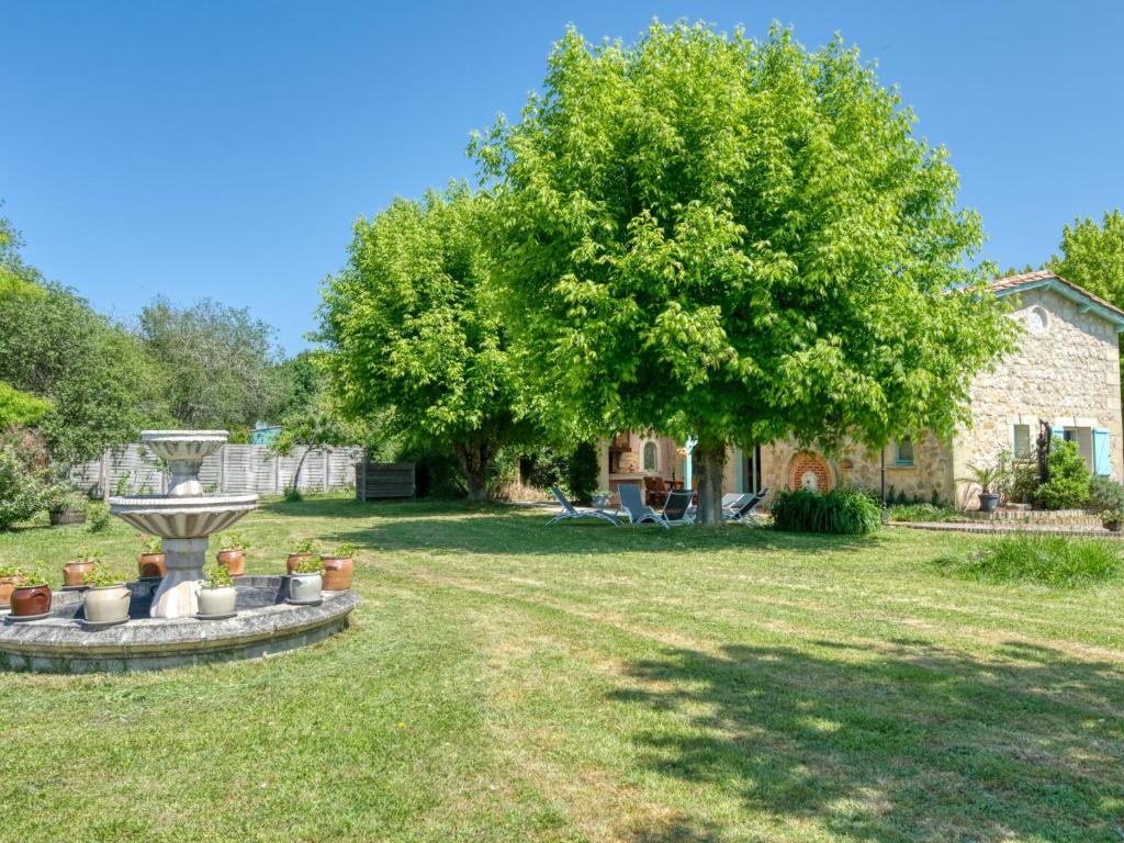 un patio con un árbol y una fuente en Holiday Home Babelle - GEM110 by Interhome, en Gaillan-en-Médoc