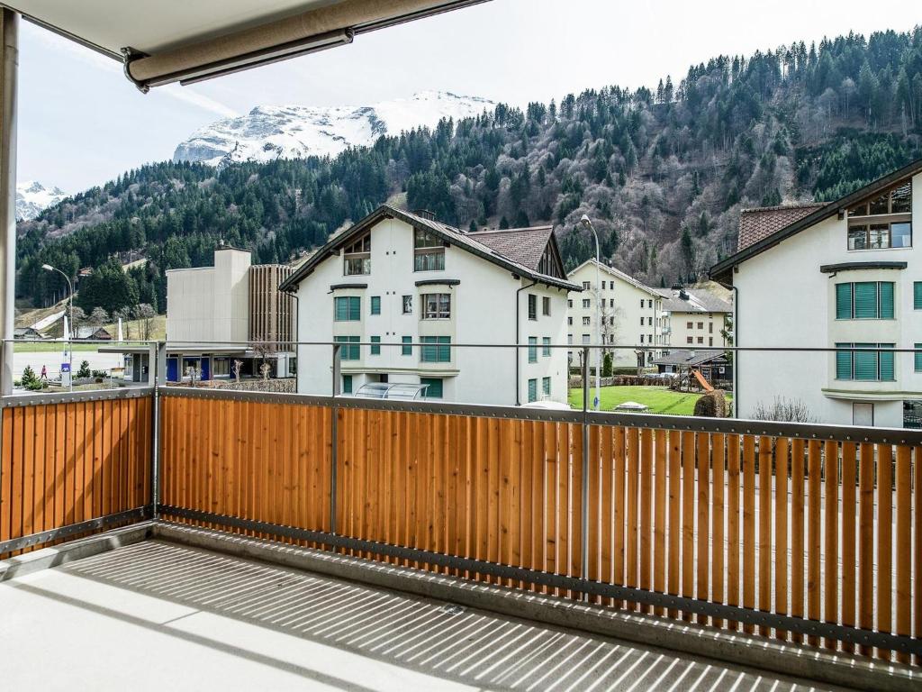 einen Balkon mit einem Holzzaun und Gebäuden in der Unterkunft Apartment TITLIS Resort 4-Zimmer Dachwohnung 6 in Engelberg