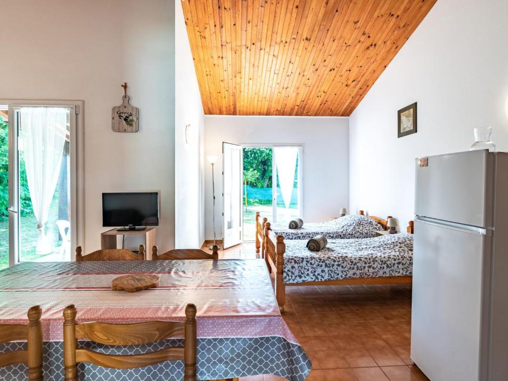 a living room with two beds and a refrigerator at Holiday Home La Pinede - SAG171 by Interhome in Sagone