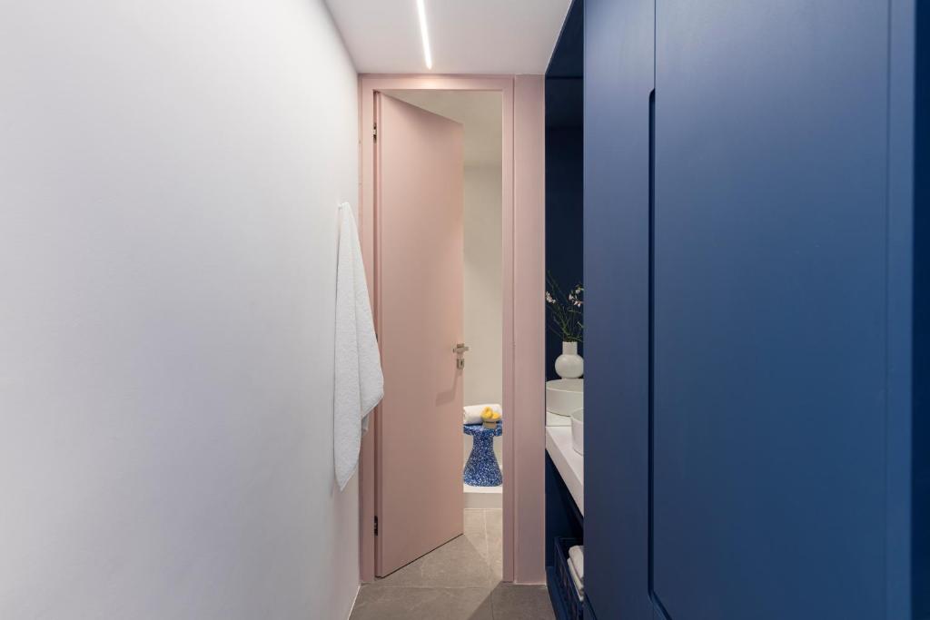 a hallway with a blue door leading to a bathroom at Neo Suites in Fira