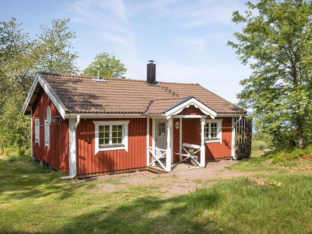 un cobertizo rojo con una puerta blanca en un patio en Holiday Home Lunnekullen - VGT122 by Interhome, en Tibro