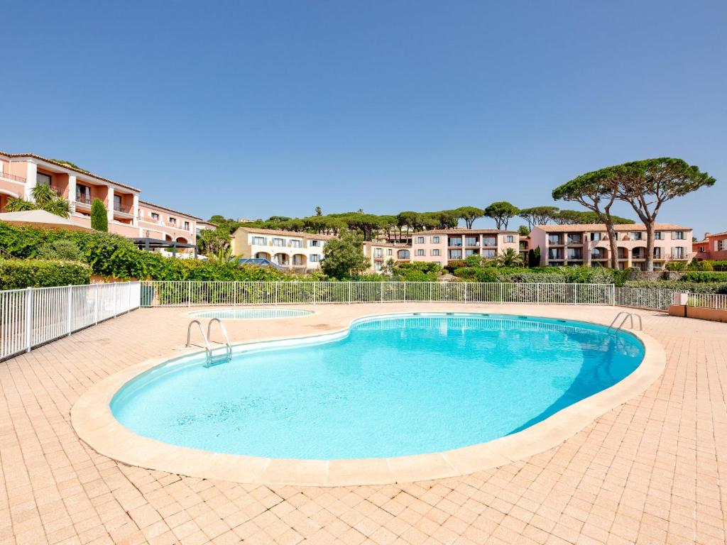 a large swimming pool in a brick yard with houses at Apartment Le Thalassa 1 by Interhome in Sainte-Maxime