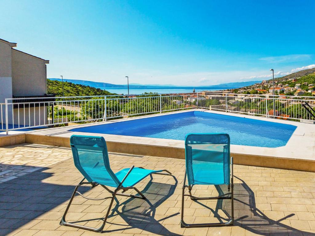 - deux chaises bleues installées à côté de la piscine dans l'établissement Apartment Miškulin-1 by Interhome, à Senj