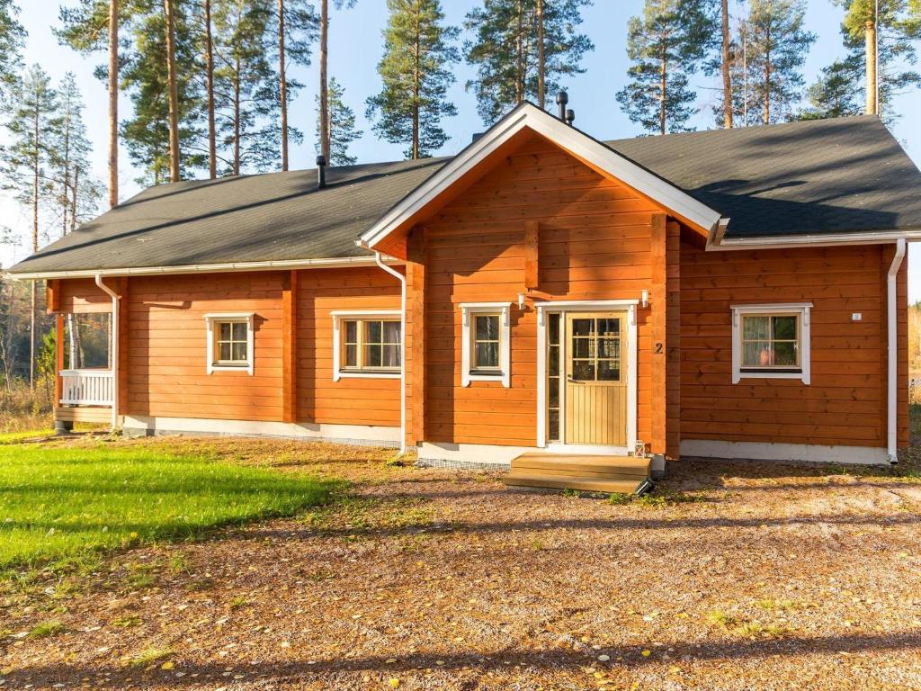 a small wooden house with a porch at Holiday Home Lokinsiipi by Interhome in Vähäsalmi