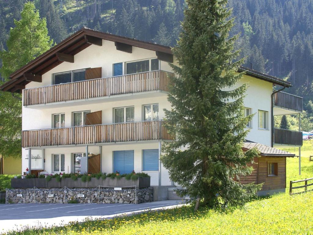 a large house with a tree in front of it at Apartment Hutter by Interhome in Churwalden