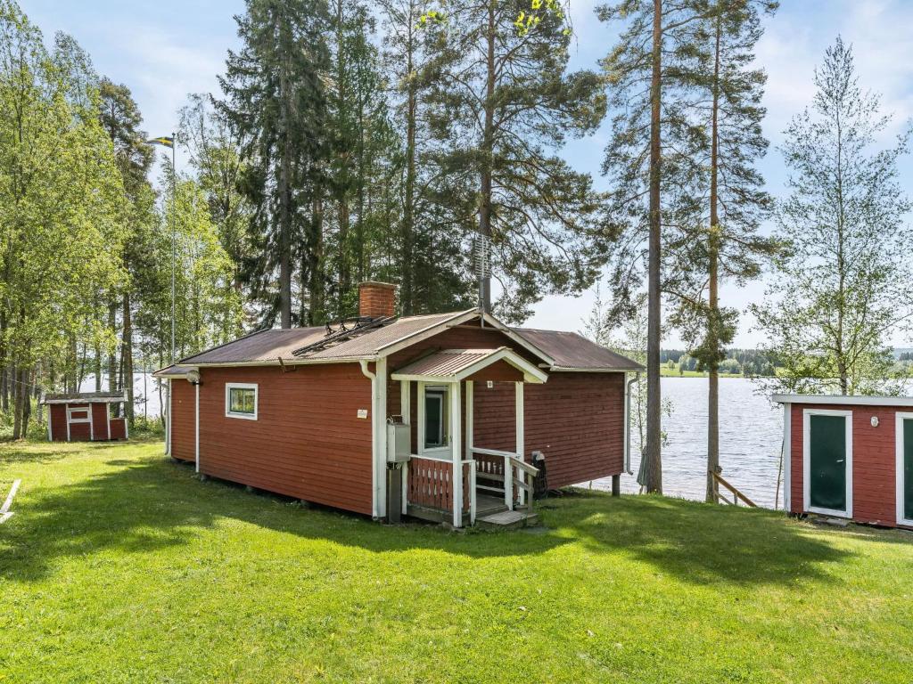 eine kleine Hütte auf einem Rasen neben einem Wasserkörper in der Unterkunft Chalet Löaborn by Interhome in Kopparberg