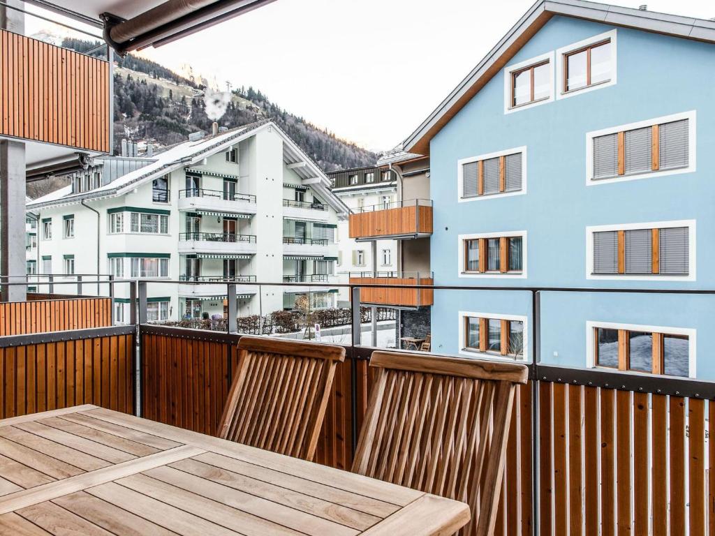 einen Balkon mit einem Holztisch und einige Gebäude in der Unterkunft Apartment TITLIS Resort 2-Zimmer Wohnung 9 by Interhome in Engelberg