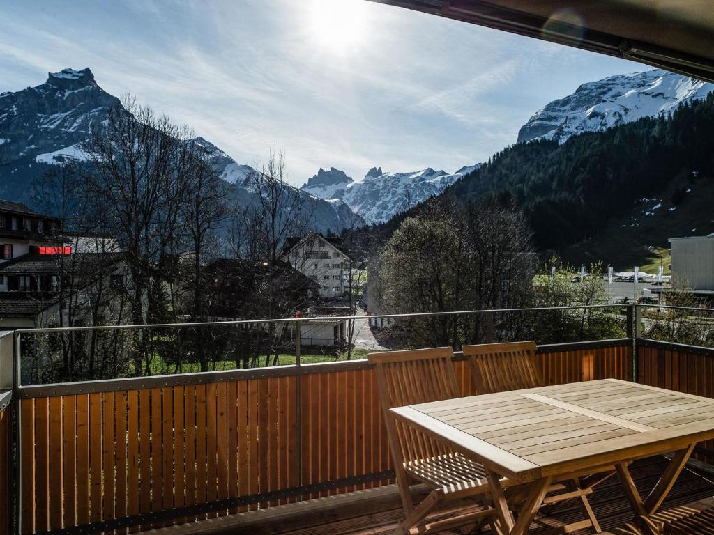 uma varanda com uma mesa e vista para as montanhas em Apartment TITLIS Resort 3-Zimmer Wohnung 22 by Interhome em Engelberg