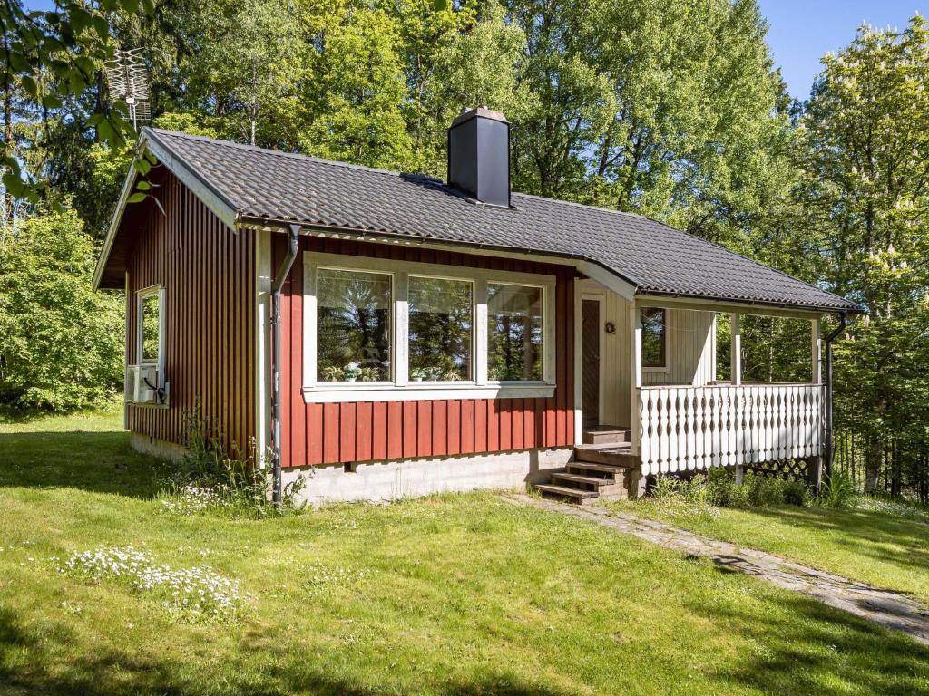 een klein rood-wit huis in een tuin bij Chalet Mjöhult Skogen - HAL022 by Interhome in Ätran