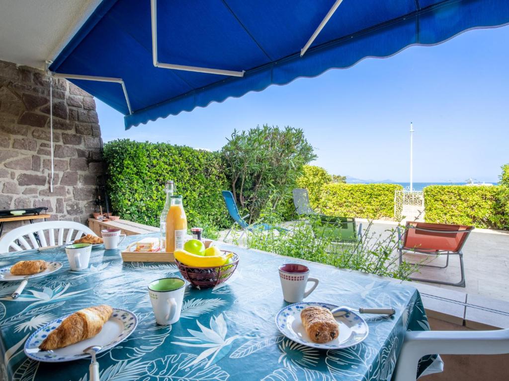 a blue table with plates of food on it at Apartment Les Mouettes by Interhome in Saint-Aygulf