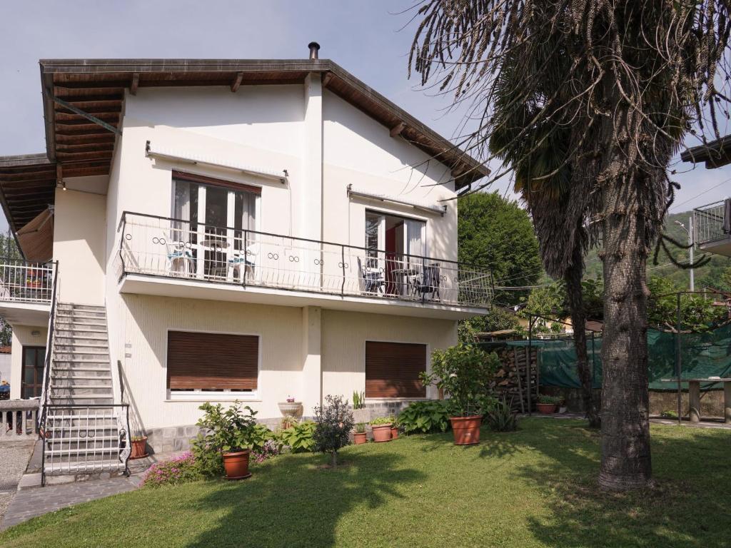 een wit huis met een balkon en een boom bij Apartment Il Gallo Nero by Interhome in Brezzo