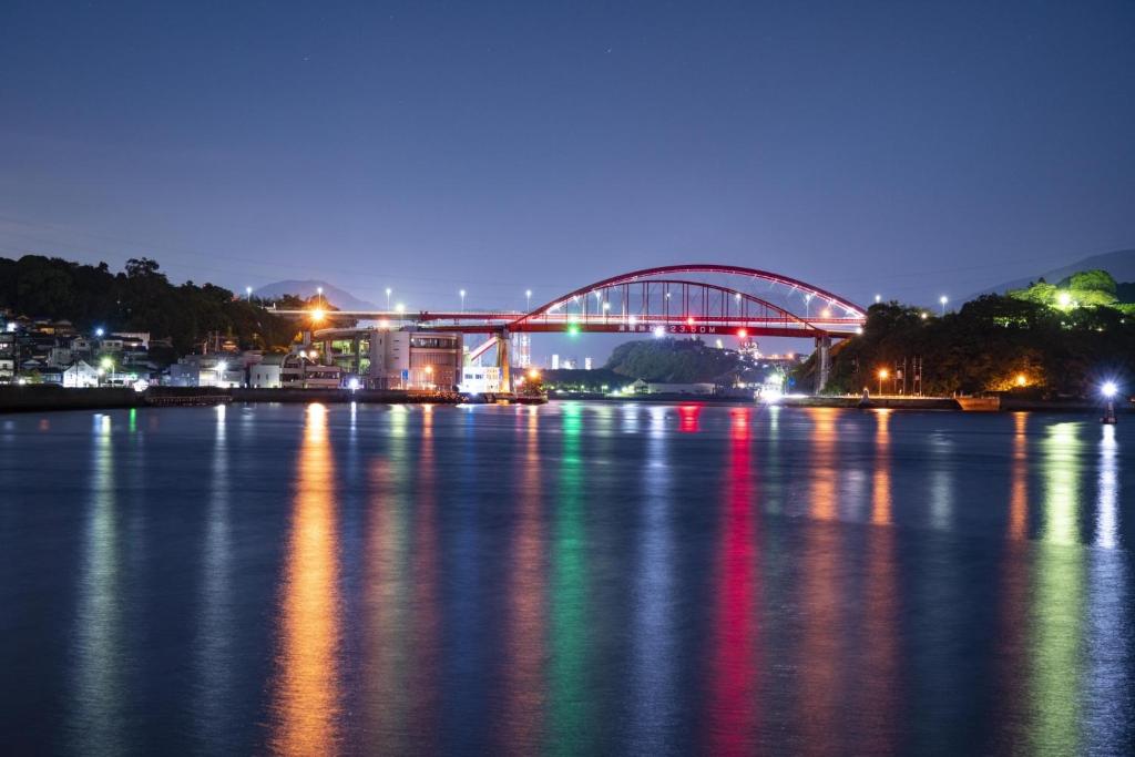 a bridge over a body of water at night at Guesthouse SETOUCHI LIFE in Kure