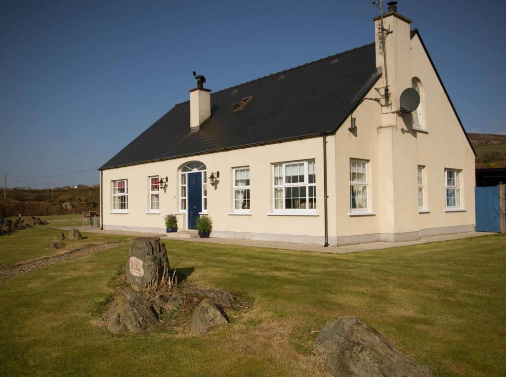 a white house with a black roof on a field at Dunagree Bed & Breakfast in Greencastle