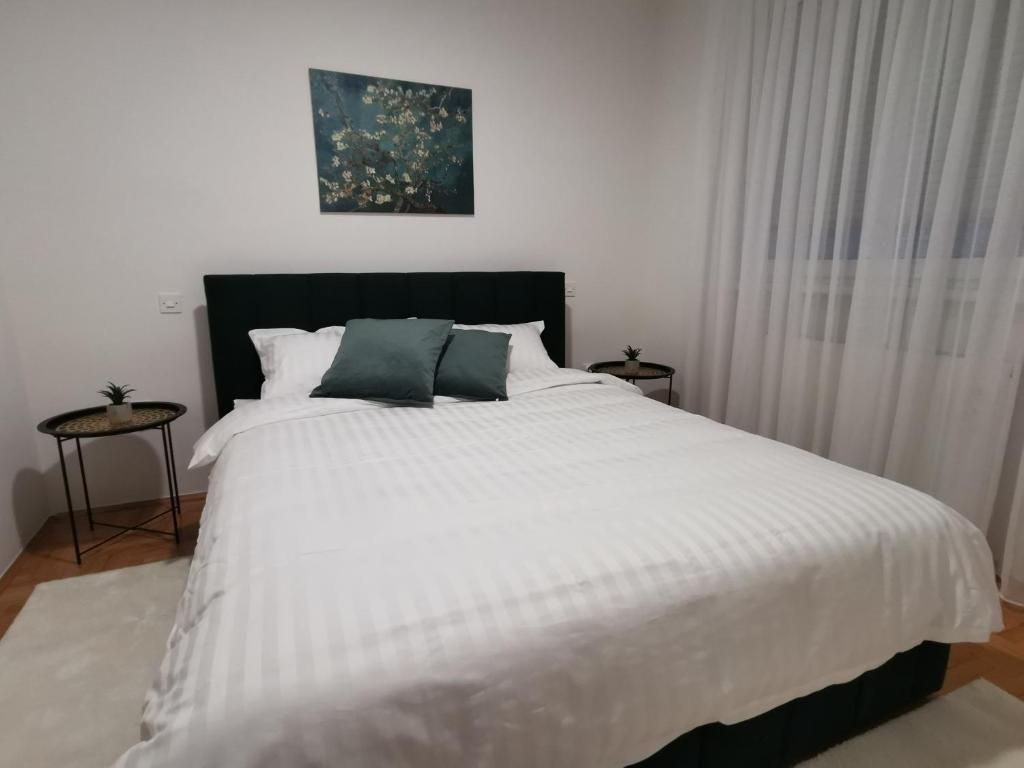 una camera con letto bianco e testiera nera di Family apartment Tuzla (100 m2) a Tuzla