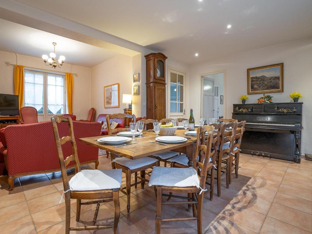 a dining room with a table and chairs and a piano at Holiday Home Ker Maria by Interhome in Saint Malo
