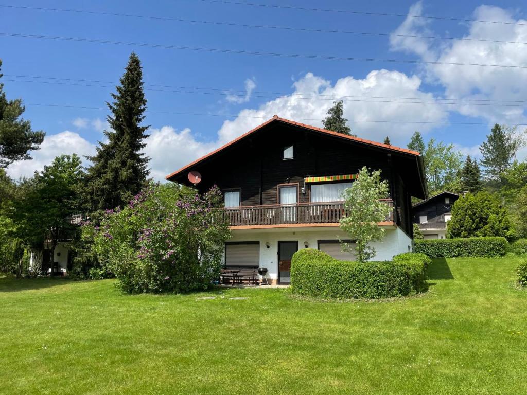 a large house with a large yard with green grass at Holiday Home Am Hohen Bogen-44 by Interhome in Arrach