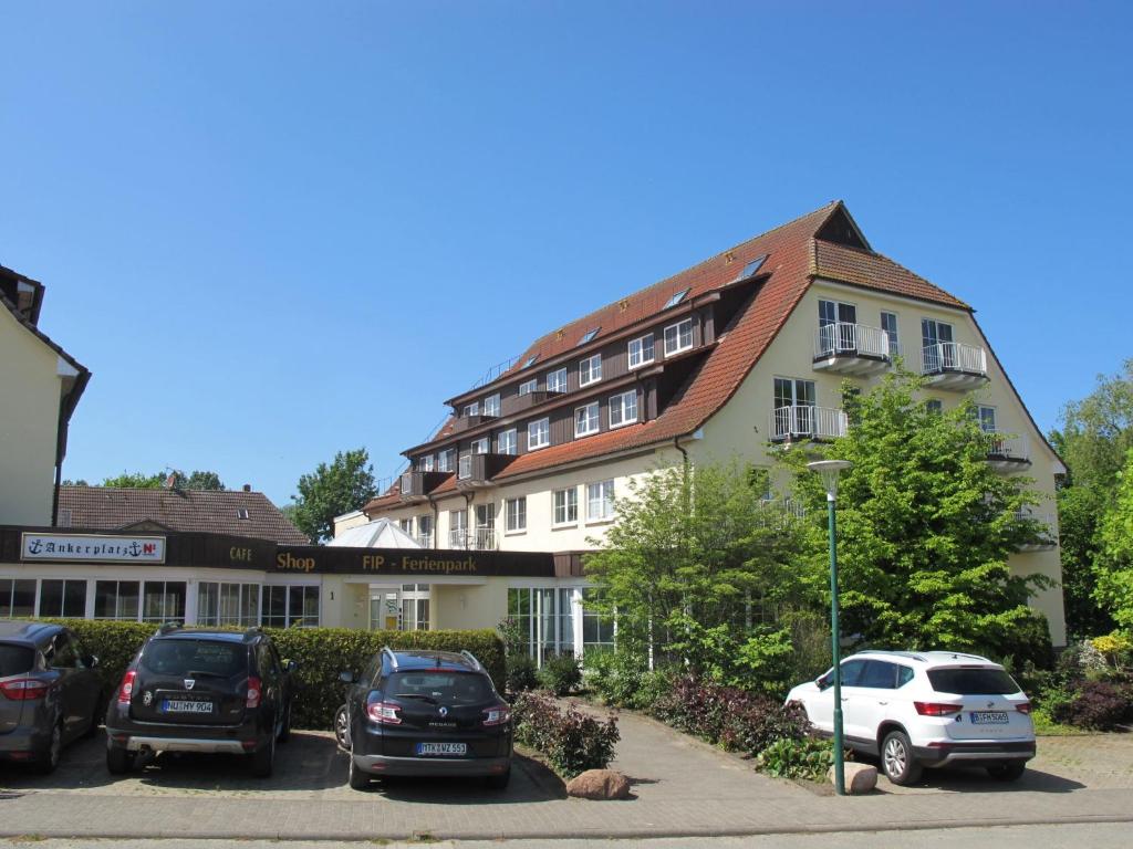 un bâtiment avec des voitures garées dans un parking dans l'établissement Apartment FIP-Ferienpark - Insel Poel-1 by Interhome, à Gollwitz