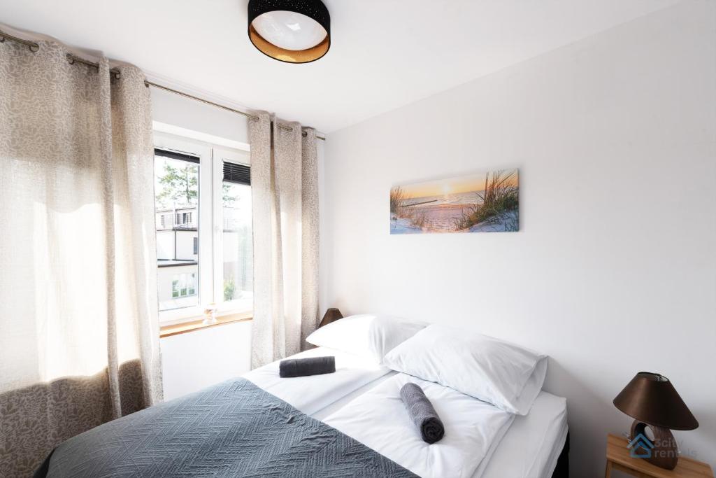 una camera bianca con un letto e una finestra di Uroda Morza by 3City Rentals a Gdynia