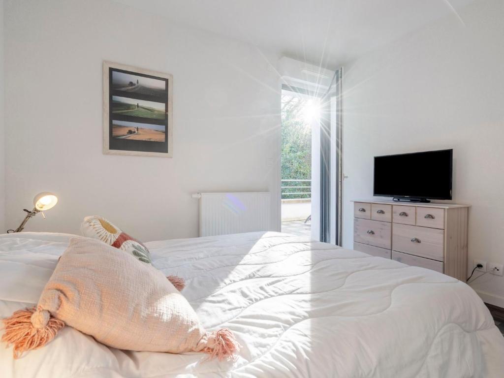 Schlafzimmer mit einem großen weißen Bett und einem TV in der Unterkunft Apartment Résidence Hego Alde by Interhome in Saint-Jean-de-Luz