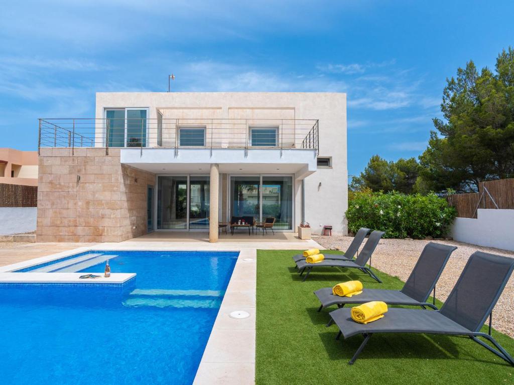 une villa avec une piscine en face d'une maison dans l'établissement Villa Villa Carme by Interhome, à Colònia de Sant Pere