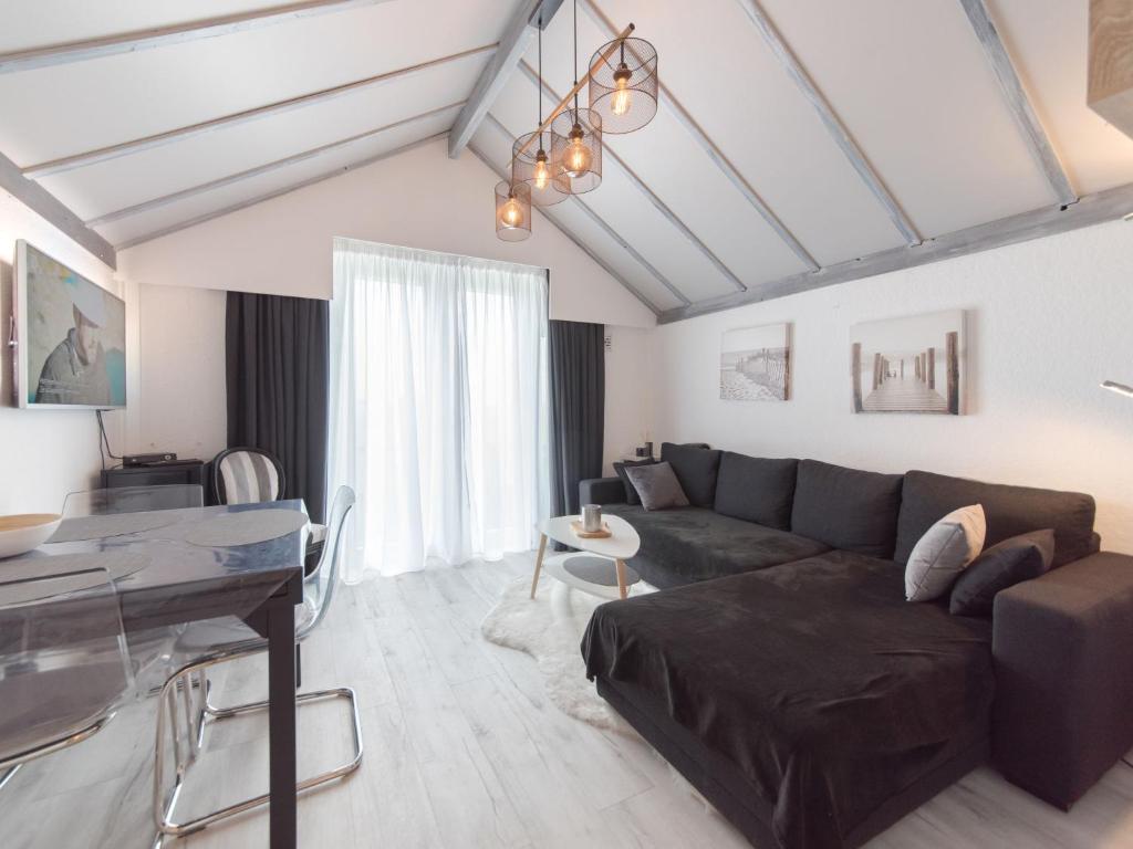 a living room with a couch and a table at Apartment La Bella Vita parking and shared pool by Interhome in De Haan