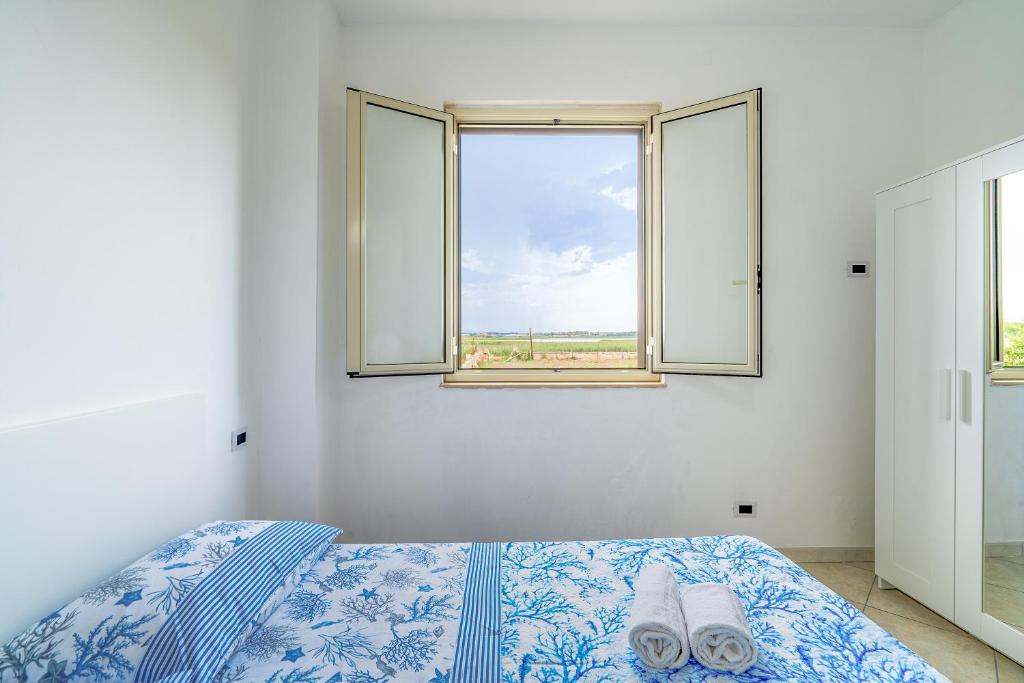 a bedroom with a bed and a window at La Nassa in Pachino