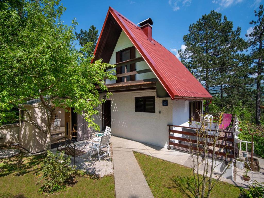 ein Haus mit einem roten Dach und einer Veranda in der Unterkunft Chalet Nina by Interhome in Lič