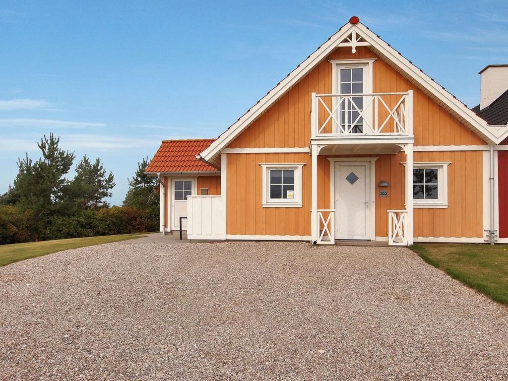 une grande maison orange avec une allée en gravier dans l'établissement Holiday Home Matleena - 200m from the sea in Funen by Interhome, à Bro