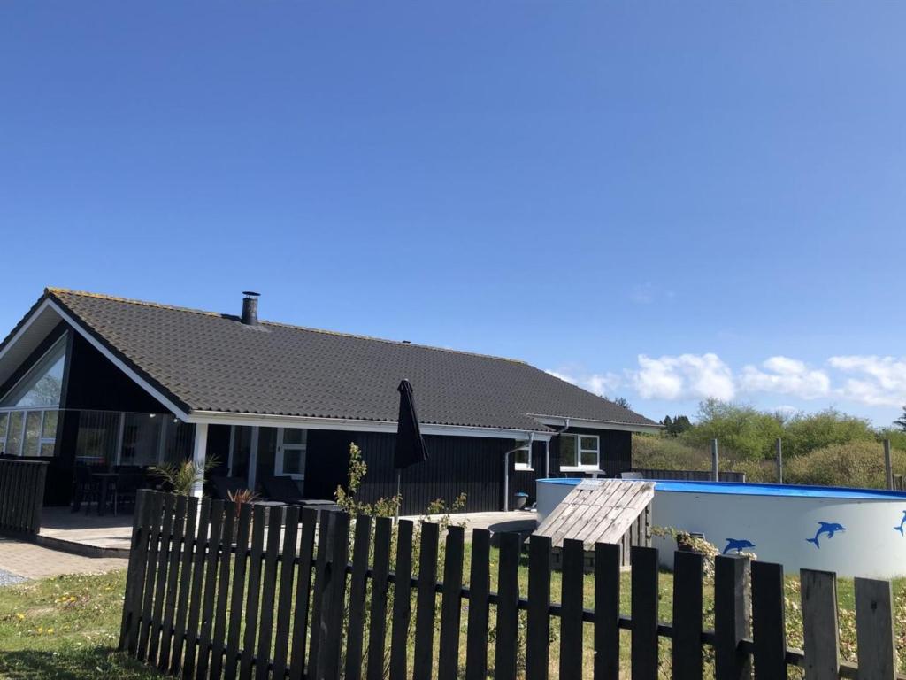 a house with a fence and a swimming pool at Holiday Home Asel - 4km from the sea in NW Jutland by Interhome in Brovst
