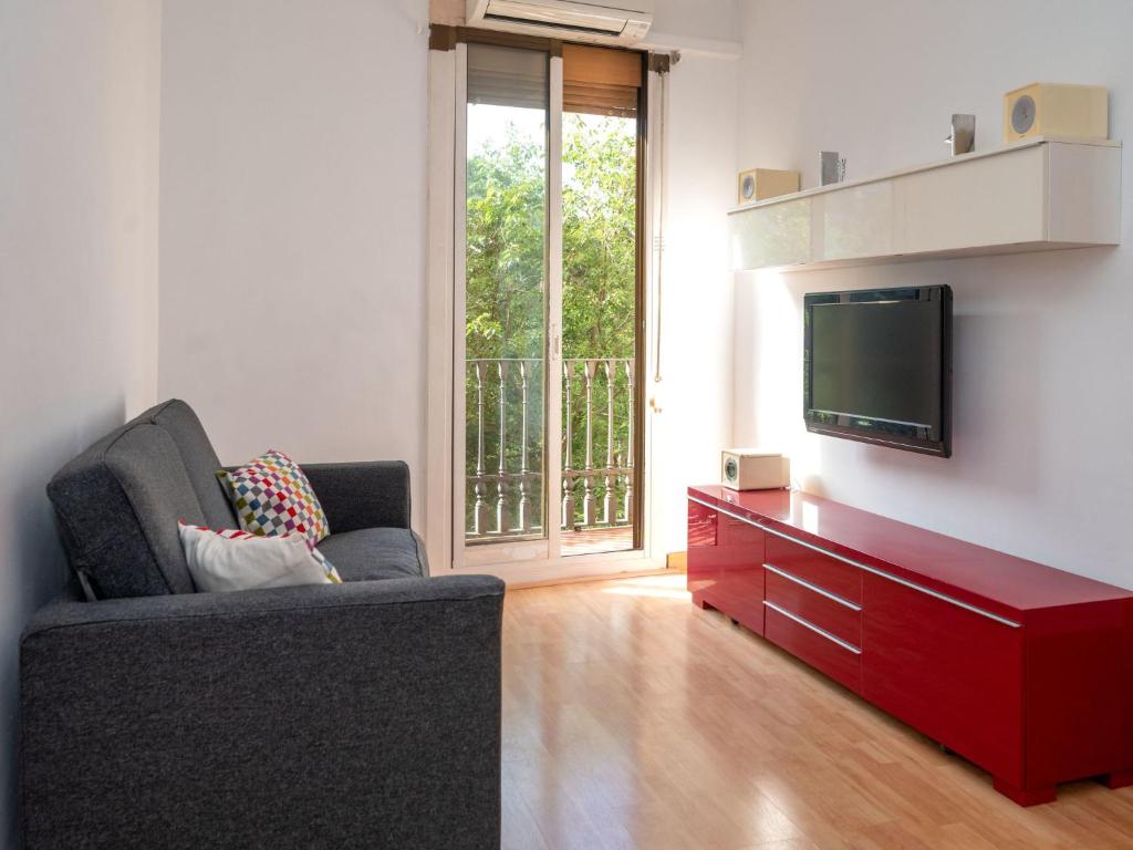uma sala de estar com um sofá e uma televisão de ecrã plano em Apartment Barcelona Centric Apartment by Interhome em Barcelona