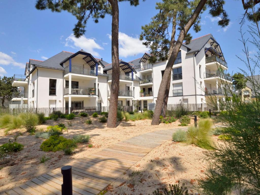 un grand immeuble blanc avec une passerelle en bois dans l'établissement Apartment Villa Sophia by Interhome, à La Baule