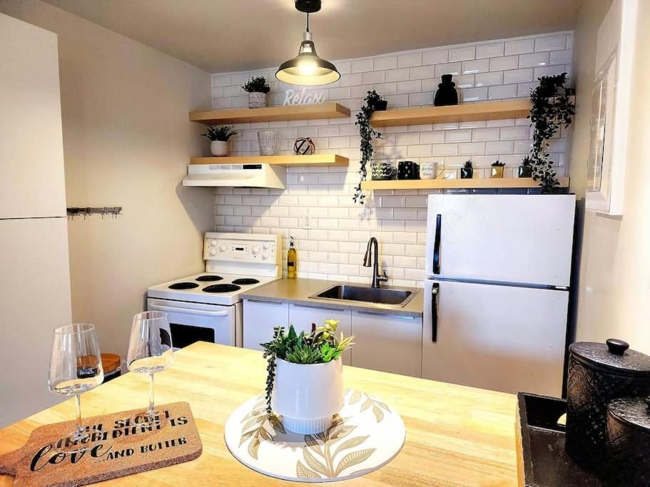 a kitchen with a white refrigerator and a table at Loft bien situé pour découvrir Vieux-Québec! in Quebec City