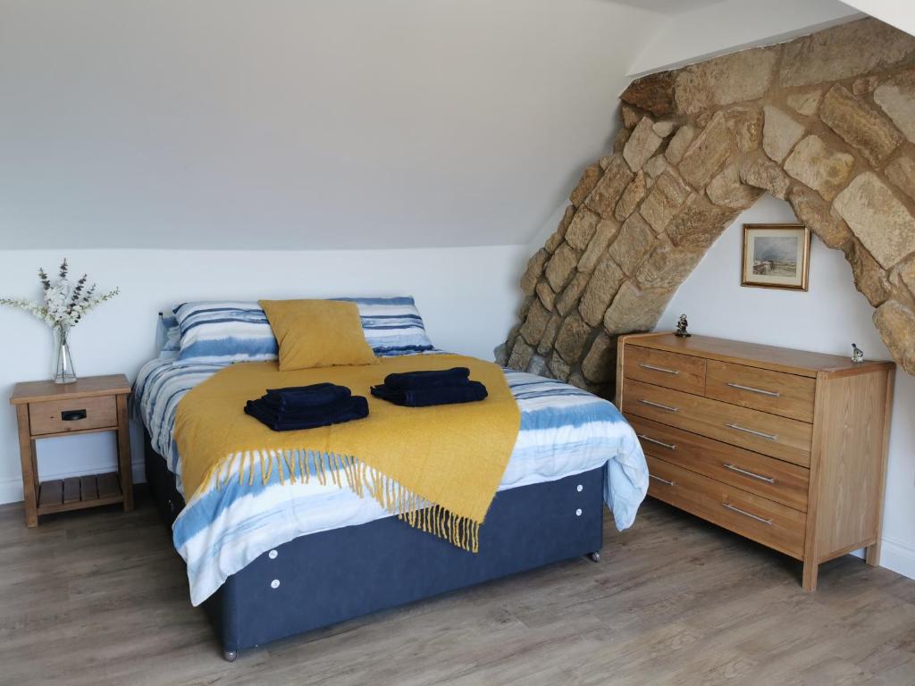 um quarto com uma cama e uma parede de pedra em SeaSky em Portland