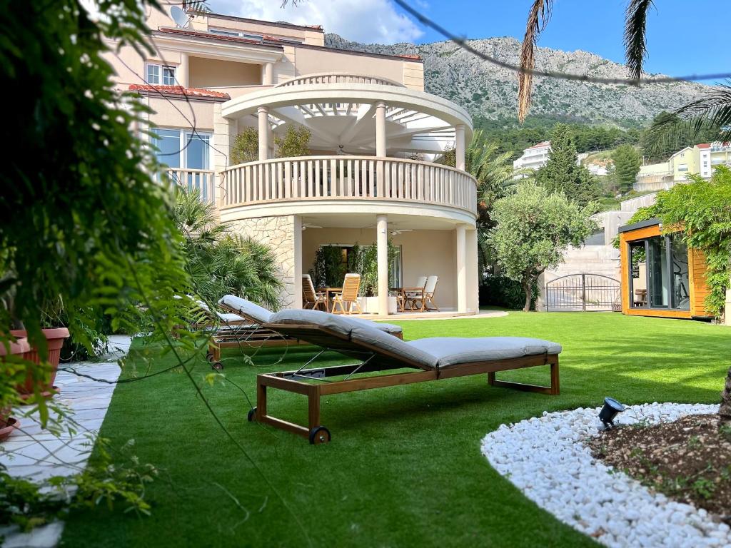 a house with a couch on the grass in the yard at Villa Romana II Omis in Omiš