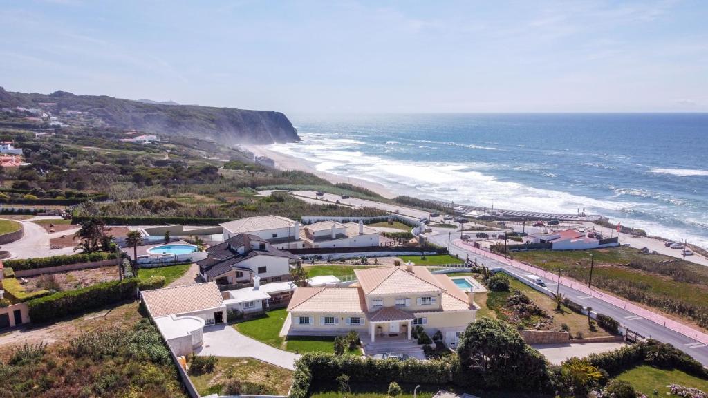 an aerial view of a house and the ocean at Praia Grande Guest House in Colares