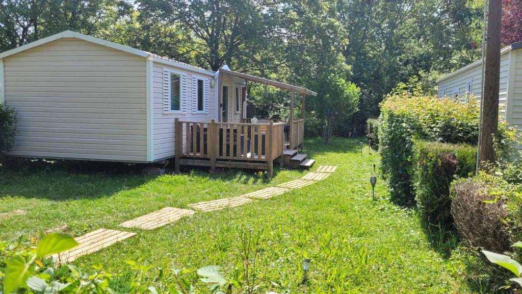 a small white cabin in a yard with a deck at MobilHome Laura EUROPAPARK 20min in Boofzheim