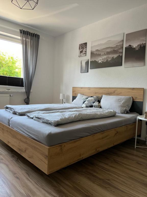 ein Schlafzimmer mit einem großen Bett mit einem Holzrahmen in der Unterkunft Apartment in Weiden i. d. Opf. in Weiden
