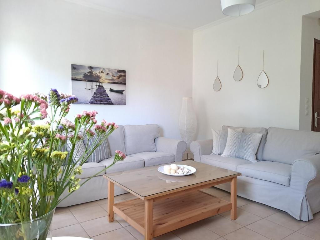 a living room with two couches and a coffee table at Maison Du Lac in Kanoni