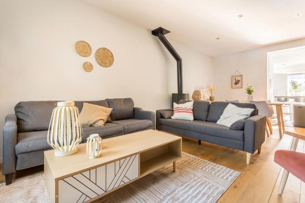 a living room with a couch and a table at Le Cottage de l'Hippodrome. in Lambersart