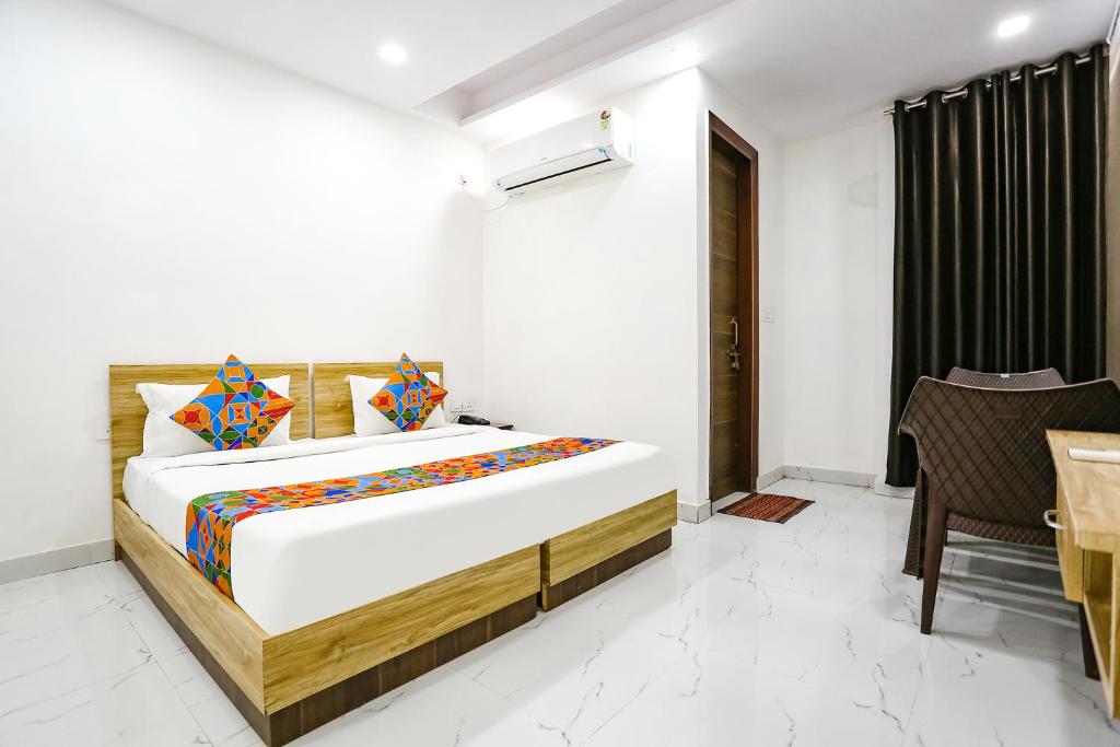 1 dormitorio con 1 cama grande y 1 mesa en FabHotel Silver Crown, en Nueva Delhi