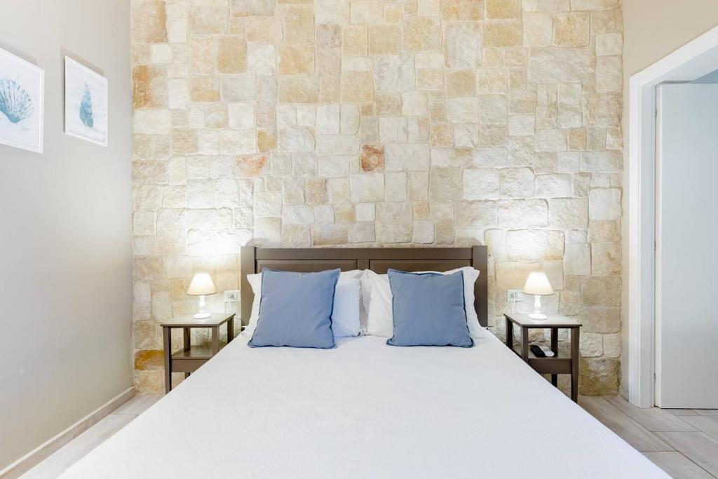 a bedroom with a large bed with blue pillows at Torrelama Room & Breakfast in Trani