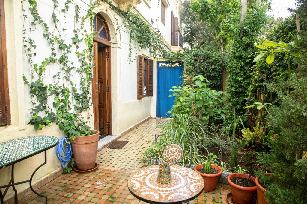 a patio with a table and plants and a blue door at Historic Rue de la Kasbah Villa in Tangier