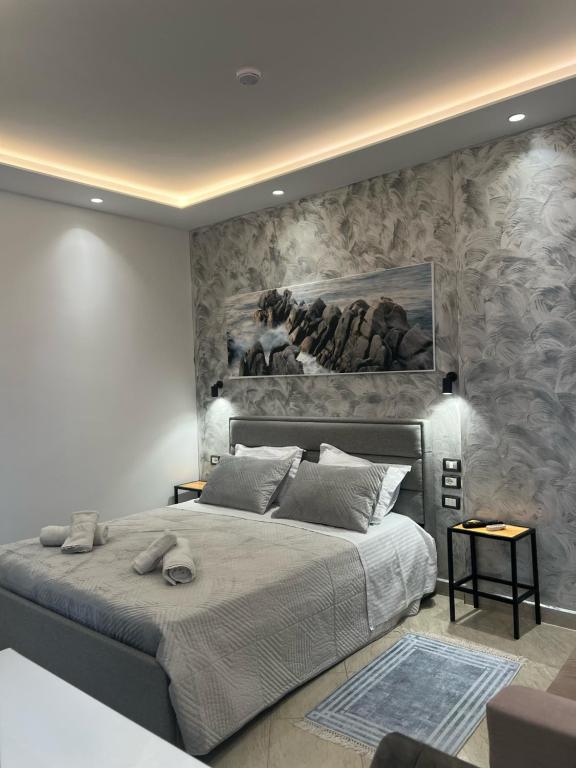 ein Schlafzimmer mit einem großen Bett und einem Gemälde an der Wand in der Unterkunft Hotel Ergi in Durrës